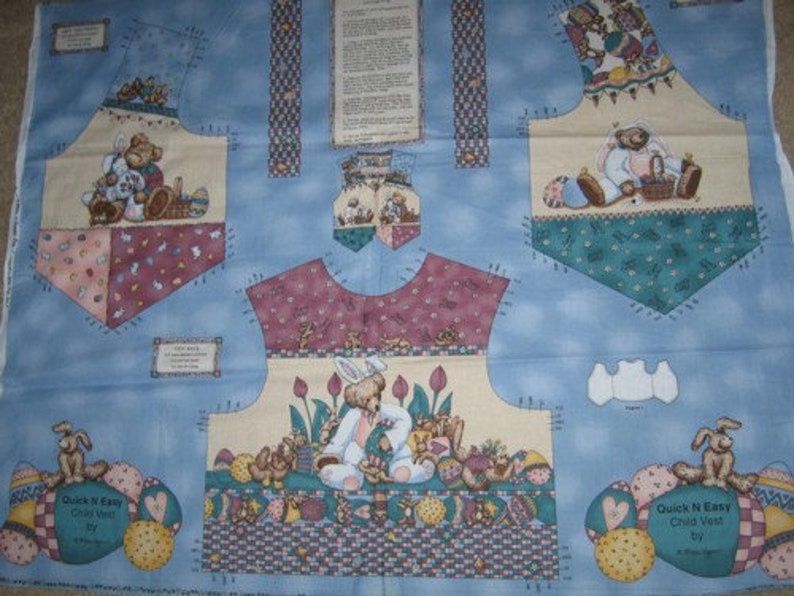 May include: A blue fabric panel with a patchwork design featuring various images of bears, bunnies, and eggs. The panel includes instructions for a "Quick 'n Easy Child Vest" project.