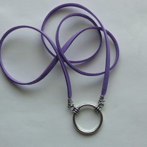 May include: A purple suede cord necklace with a silver circle pendant.