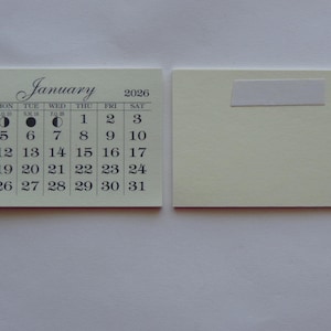May include: A white calendar with black text shows the month of January 2026. The calendar is divided into seven columns for each day of the week, starting with Sunday and ending with Saturday. The calendar also includes moon phases for each day.