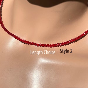 Può includere: Viene mostrata una delicata collana di perline rosse, Stile 2. La collana è composta da piccole perline sfaccettate, creando un effetto scintillante. Il testo "Length Choice" è visibile.