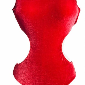 K&ouml;nnte beinhalten: Ein roter Samt-Bodysuit mit Rundhalsausschnitt und Ausschnitten an den Seiten.