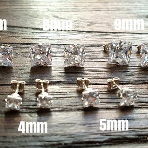 May include: A set of 10 pairs of silver square stud earrings with clear cubic zirconia stones. The earrings are arranged in rows by size, from 3mm to 9mm.