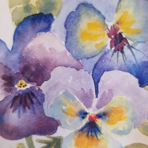 May include: Watercolour painting of three purple, blue, and yellow pansies with green leaves.