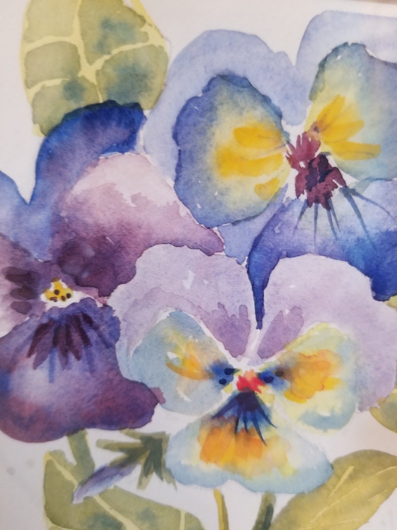 May include: Watercolour painting of three purple, blue, and yellow pansies with green leaves.