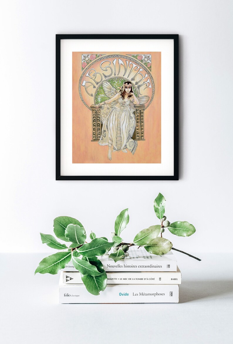 May include: A framed illustration of a fairy sitting on a throne with the word "Absinthe" written in a decorative font. The fairy is wearing a white dress and has green wings. The background is a peach color.
