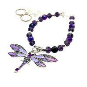 May include: A beaded bracelet with a dragonfly charm. The bracelet features purple and black beads, with a silver-toned clasp and a dragonfly pendant. The dragonfly has purple and silver details. Two silver-toned key rings are attached to the bracelet.