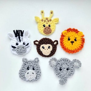 Puede incluir: Seis caras de animales de ganchillo, incluyendo una cebra, una jirafa, un mono, un león, un hipopótamo y un elefante. Cada cara está hecha con puntadas detalladas y colores vibrantes, ideal para manualidades infantiles o decoración de guardería.