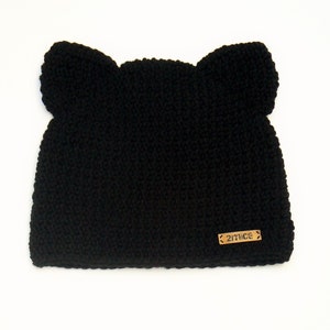 May include: Black knitted hat with ear flaps and a brown leather tag that says "27NICE".