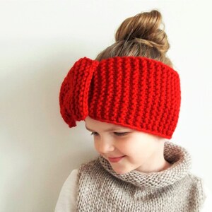 May include: Red knitted headband with a large bow on top. The headband is made of a soft, warm yarn and is perfect for keeping your ears warm in the winter.