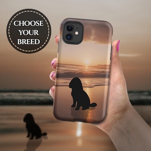 May include: A smartphone case featuring a sunset beach scene with a dark silhouette of a dog sitting on the sand. The case has a dual-camera cutout and the text CHOOSE YOUR BREED is printed in a circular badge in the upper left corner.