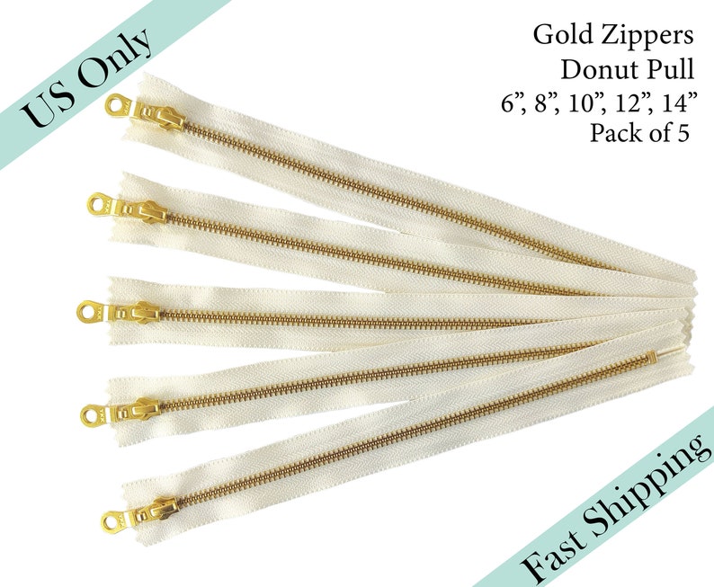 May include: Five gold zipper pulls with a donut shape. The zippers are 6, 8, 10, 12, and 14 inches long. The zippers are white with gold teeth and a gold pull.