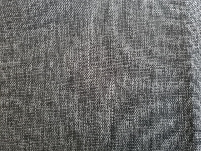 May include: Close-up of a gray textured fabric with a subtle woven pattern.