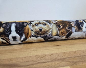 Può includere: Tessuto con un motivo ripetuto di adorabili cuccioli. I cuccioli hanno vari colori di pelo, tra cui bianco e nero, marrone e beige. Il tessuto è probabilmente utilizzato per progetti di artigianato o di arredamento per la casa.