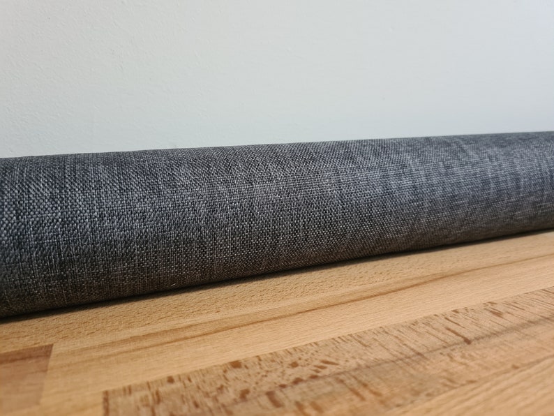 May include: A rolled up gray fabric with a textured surface.