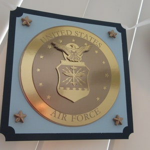 May include: A blue and gold United States Air Force banner with a gold eagle and shield emblem. The banner has a navy blue border and gold stars.