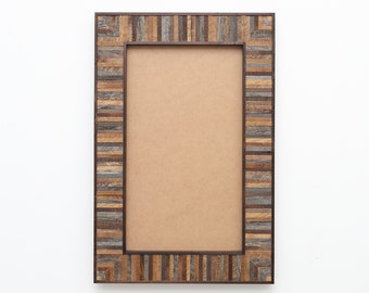 May include: Rectangular wooden picture frame with a brown and gray mosaic pattern. The frame has a dark brown inner border and a light brown backing. The frame is designed to hold a rectangular photo.