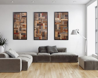 May include: Three framed wood wall art pieces with a geometric pattern of various shades of brown, gray, and red wood. The art is hanging on a white wall above a gray sectional sofa.