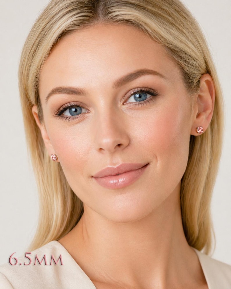 A woman wearing pair of four prong silver stud earrings set with 6.5mm round lab created padparadscha sapphires. Model image for size and styling reference — not a photo of the actual earrings.