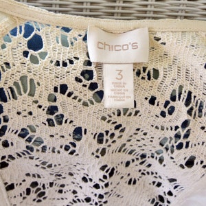 May include: A white lace top with a "Chico's" tag and a size 3 label. The label says "Made in China, Hecho en China, Fabrique en Chine".