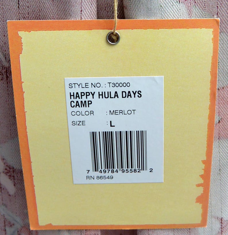 May include: A yellow tag with an orange border is suspended by a string. The tag displays the text "HAPPY HULA DAYS CAMP" and "MERLOT" color. The size is listed as "L". A barcode and the number "7 49784 95582 2" are also visible.