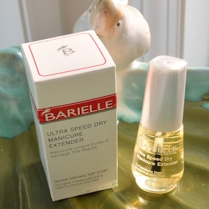 May include: A bottle of Barielle Ultra Speed Dry Manicure Extender next to its box. The box is white with red accents and text. The bottle is clear with a white cap. The product is a quick drying top coat, toluene, formaldehyde & dibutyl phthalate free.