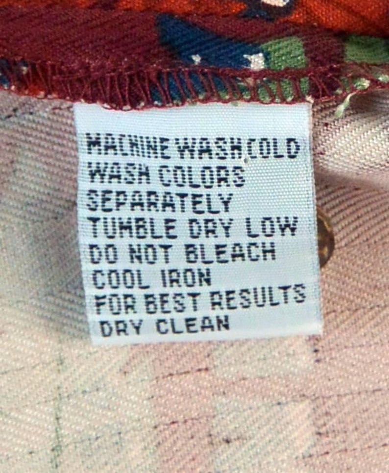 May include: A white fabric tag with black text, including washing instructions: Machine wash cold, wash colors separately, tumble dry low, do not bleach, cool iron, for best results, dry clean.