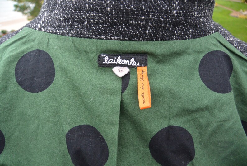 May include: A green and black polka dot jacket with a black tweed collar and a label that reads "taikonhus made in Italy."