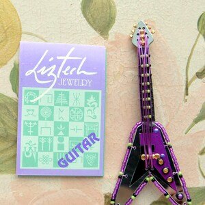 VENTE ! Broche guitare Liztech Flying V - inutilisée - signée, carte originale, verre rétro, fabriquée à la main, excellent cadeau - vintage - rare, obsolète, fabuleuse !
