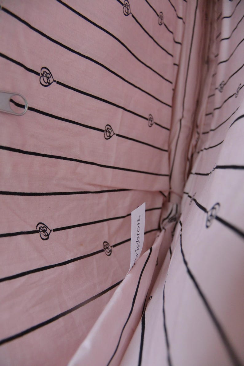 May include: Pink fabric bag interior with black striped pattern and heart motifs. A silver zip pull is visible. A white tag with the word "Brighton" is attached to the fabric.