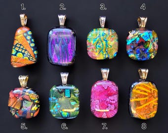 May include: Eight glass pendants with silver bail, each with a different colorful pattern. The pendants are numbered 1 through 8.