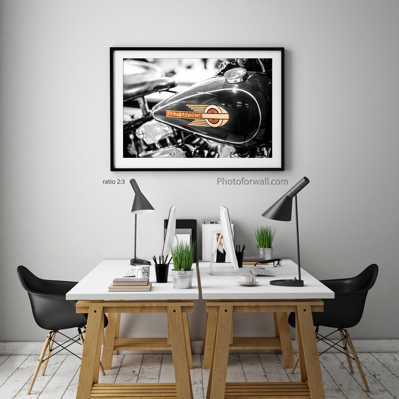 a white table with two black chairs and a picture on the wall