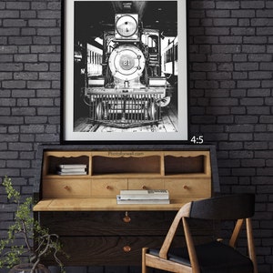 a black and white photo of a train on a brick wall