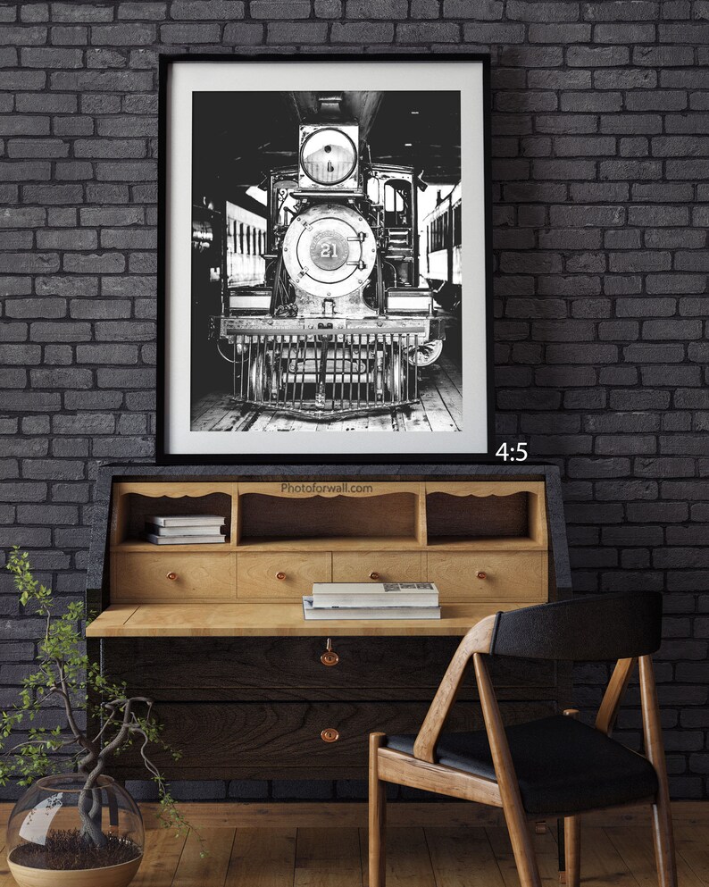 a black and white photo of a train on a brick wall