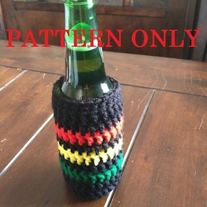 May include: A crocheted bottle cosy with black, red, yellow and green stripes. The cosy is on a bottle of beer.