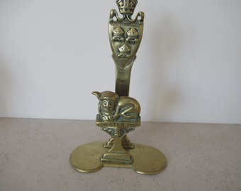 Op de afbeelding: Een messing Chester Imp sculptuur. De sculptuur toont een schild met drie kronen, een zittende imp-figuur en de woorden "CHESTER IMP" op een rechthoekige basis. De sculptuur heeft een kroon aan de bovenkant en een cirkelvormige basis.