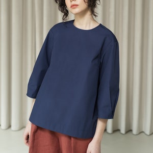 K&ouml;nnte beinhalten: Eine dunkelblaue Bluse mit Dreiviertel&auml;rmeln und Rundhalsausschnitt. Die Bluse ist aus einem weichen, leichten Stoff gefertigt und hat eine lockere Passform.