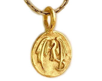 May include: A gold necklace with a round pendant featuring a detailed dragon design.