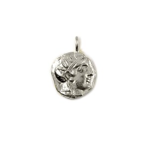 May include: Silver pendant featuring a detailed profile of a woman's face with a laurel wreath. The pendant has a slightly irregular, coin-like shape.