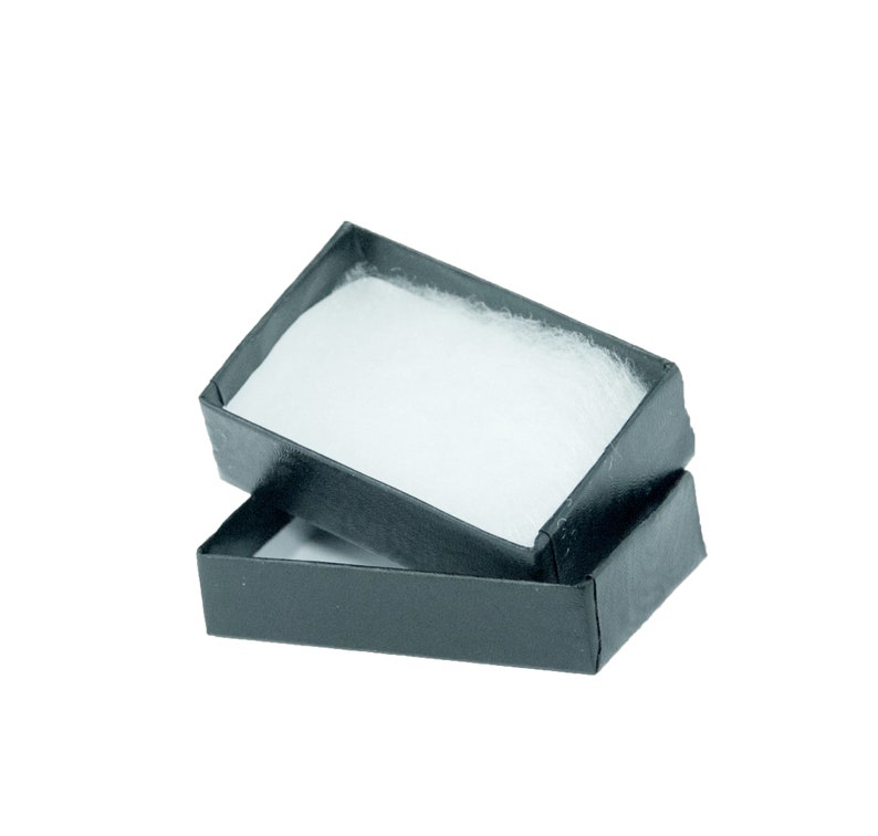 May include: An open, black rectangular gift box with a white, fluffy interior. The box is slightly ajar, revealing the soft, padded lining. The box is empty and ready for a small gift.