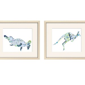 May include: Two framed prints of Australian animals. The left print features a blue and green platypus. The right print features a blue and green kangaroo.