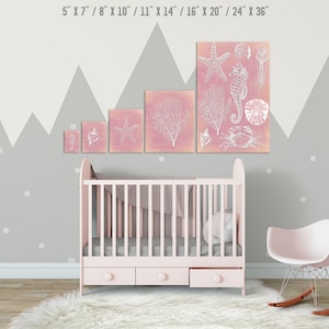 Peut inclure: Une chambre de b&eacute;b&eacute; avec un lit b&eacute;b&eacute; blanc et un fauteuil &agrave; bascule rose. Les murs sont peints en gris avec des pois blancs et un motif en forme de montagne. Il y a cinq impressions encadr&eacute;es sur le mur avec un fond rose et des illustrations blanches de la vie marine, y compris une &eacute;toile de mer, un hippocampe et du corail.