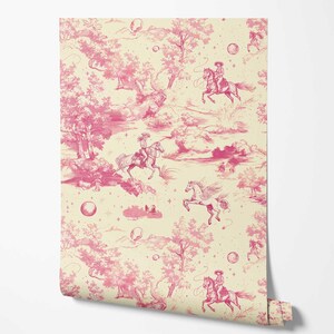 Op de afbeelding: Roze en witte behang met een herhalend patroon van cowboys die op paarden rijden in een fantasierijk landschap. Het patroon bevat wolken, sterren en andere details.