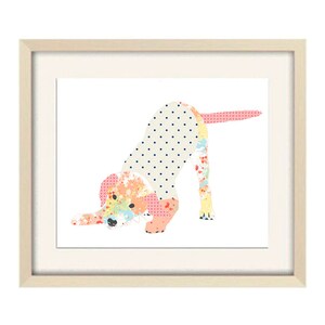 May include: A framed print of a colorful patchwork dog illustration. The dog is in a playful pose, with its head down and its tail wagging. The print is set against a white background.