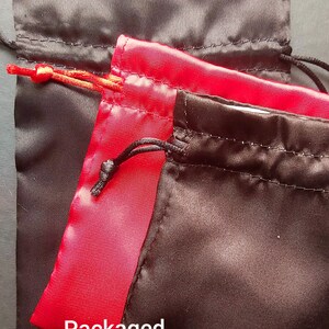 May include: Two satin gift pouches, one black and one red, with drawstrings. The pouches are stacked on top of each other. The text "Packaged in High Quality Satin Gift Pouch" is printed on the bottom of the image.