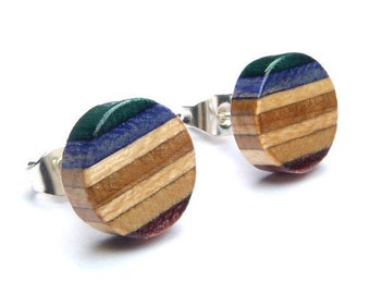 Könnte beinhalten: Ein Paar runde Holzohrringe mit einem mehrfarbigen, geschichteten Design. Die Ohrringe sind aus recyceltem Holz gefertigt und haben Farbtöne von Grün, Blau, Braun und Lila.