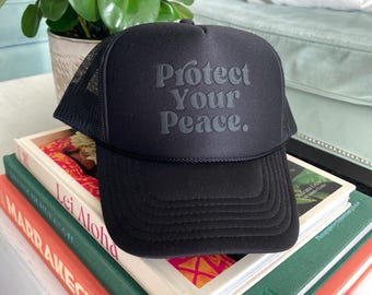 Black Trucker Hat,  &quot;Protect Your Peace.&quot;  Bubble font, Puff print