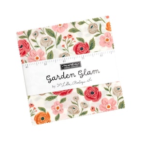May include: A stack of square fabric pieces featuring a floral pattern with pink, red, and orange flowers on a white background. A white paper band wraps around the centre, displaying the text Garden Glam by Lella Boutique and a ruler measuring 12.7 cm.