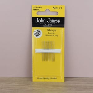 May include: A package of John James Sharps needles, size 12, containing 12 needles. The yellow and black packaging includes the text "John James Est. 1840" and "Finest Quality Needles."