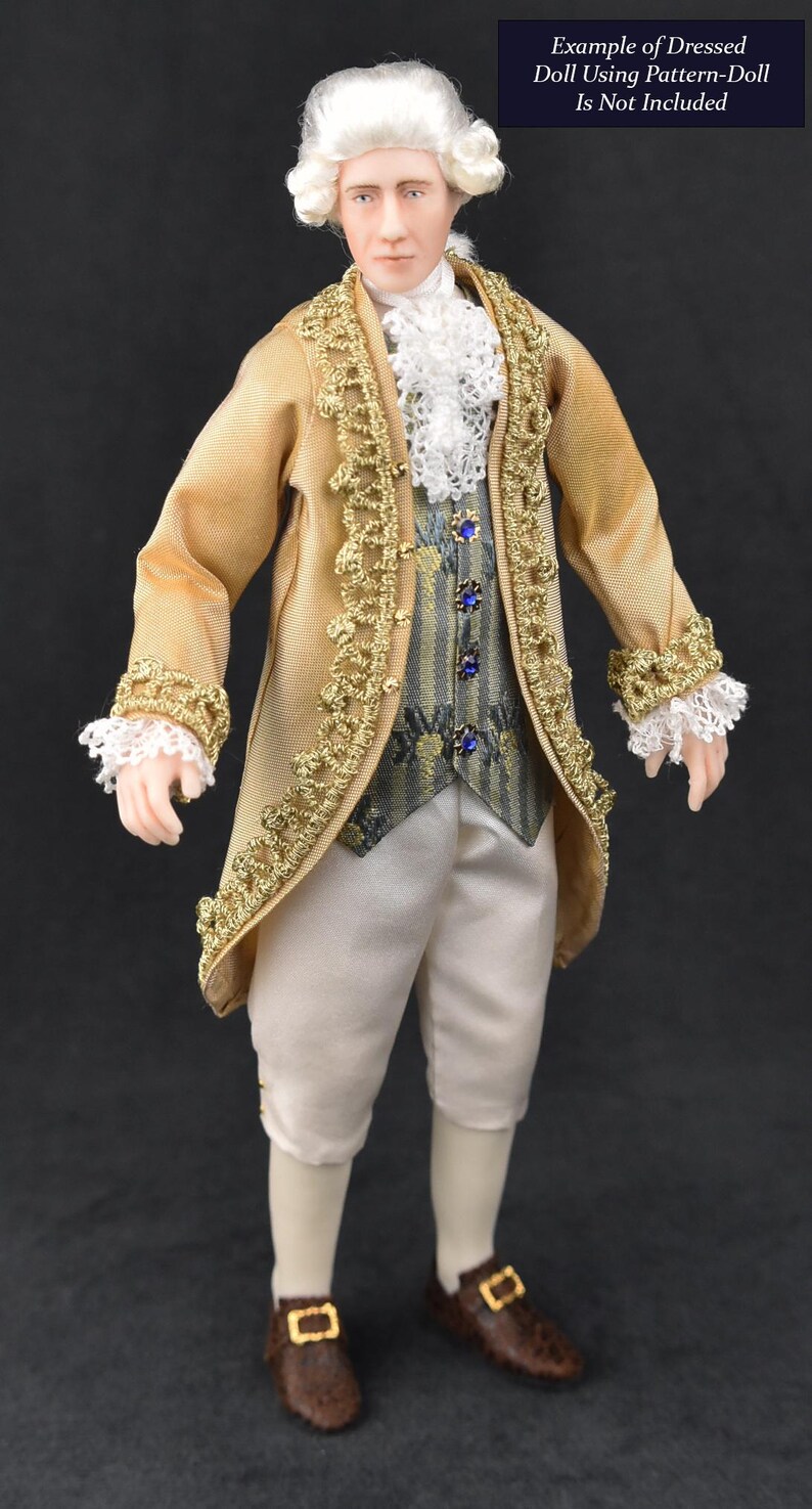 May include: A doll with white hair wearing a gold coat with gold trim, a white lace cravat, a grey patterned vest with blue buttons, and white breeches. Brown shoes with gold buckles are worn. Text reads: Example of Dressed Doll Using Pattern-Doll Is Not Included.