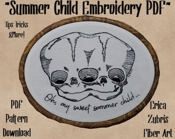 May include: Black and white embroidery art featuring a skull-like design with the text "Oh, my sweet summer child...". The artwork is set in an oval wooden frame. Text on the image includes "Summer Child Embroidery PDF" and "PDF Pattern Download".